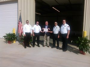Fire Department officials receive the certificate of occupancy for the North Holcomb fire station from County Commission Chair Dennis Bell